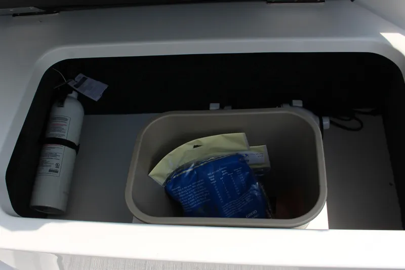 Slide: The Image of Storage compartment in 2025 Cobalt CS23 boat with fire extinguisher and container. - 27
