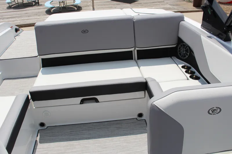 Slide: The Image of 2025 Cobalt CS23 boat interior with gray and white seating, cup holders, and speaker. - 30