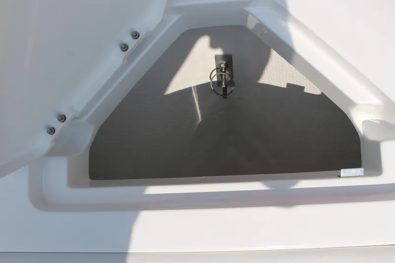 Slide: The Image of 2025 Cobalt CS23 boat storage compartment with latch, white interior. - 43