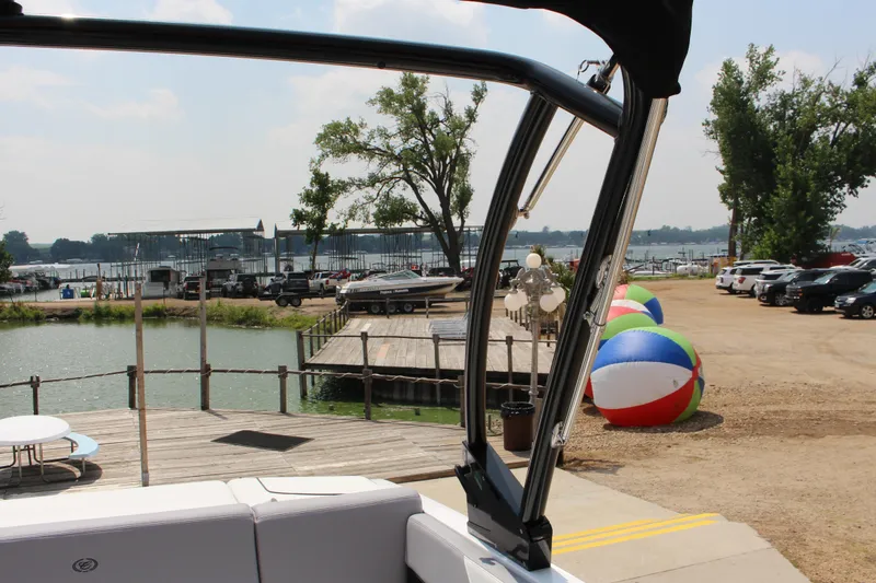 Slide: The Image of 2025 Cobalt CS23 boat at marina with colorful beach balls and parked cars. - 45