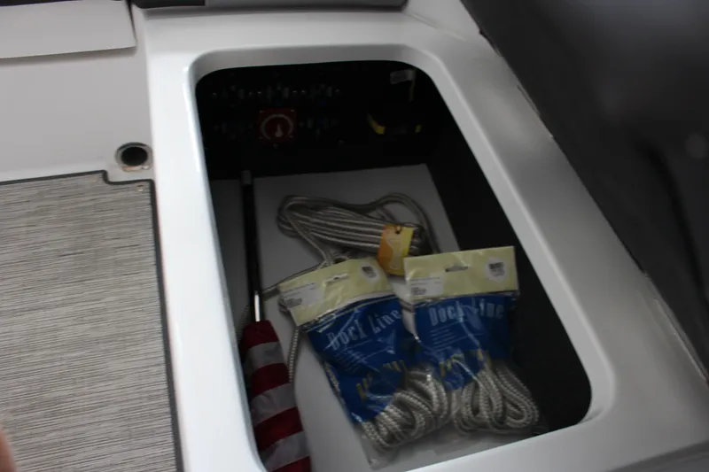 Slide: The Image of Storage compartment in 2025 Cobalt CS23 Surf boat with dock lines and accessories. - 16