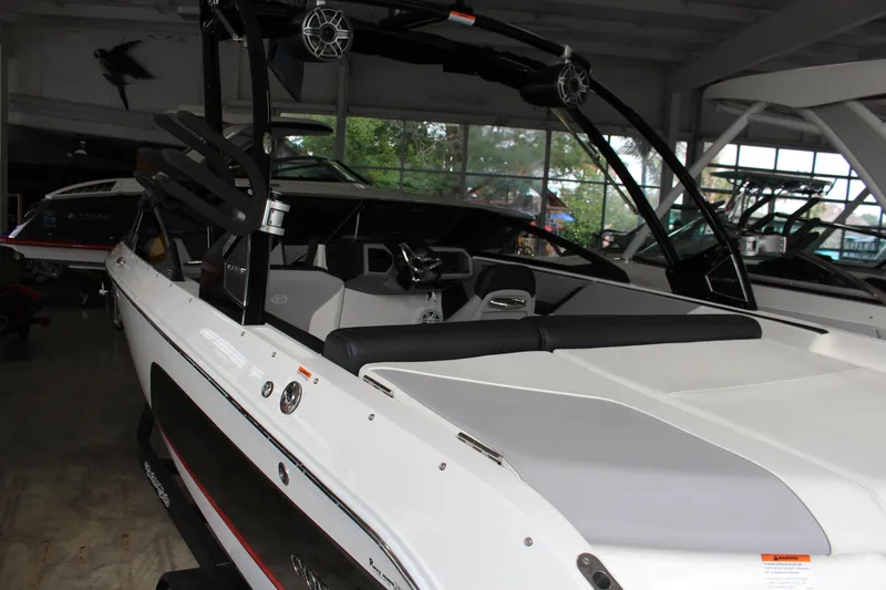 Slide: The Image of 2025 Cobalt CS23 Surf boat in showroom, featuring sleek design and modern amenities. - 2