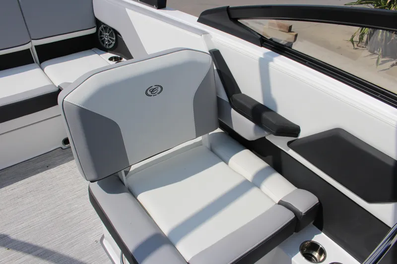 Slide: The Image of 2025 Cobalt CS23 boat interior with gray and white seating, cup holder, and speaker. - 18