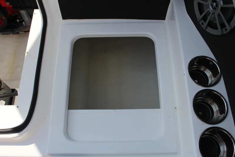 Slide: The Image of 2025 Cobalt CS23 boat interior with cup holders and storage compartment. - 28