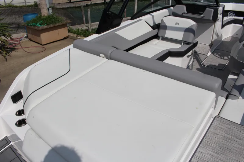 Slide: The Image of 2025 Cobalt CS23 boat interior with white and gray seating, dockside view. - 3