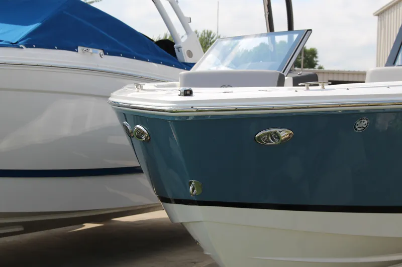 Slide: The Image of 2025 Cobalt CS23 boat with sleek blue and white design, docked outdoors. - 34