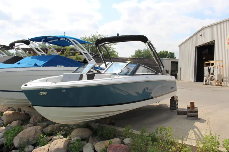 Slide: The Image of 2025 Cobalt CS23 boat displayed outdoors near a warehouse. - 35