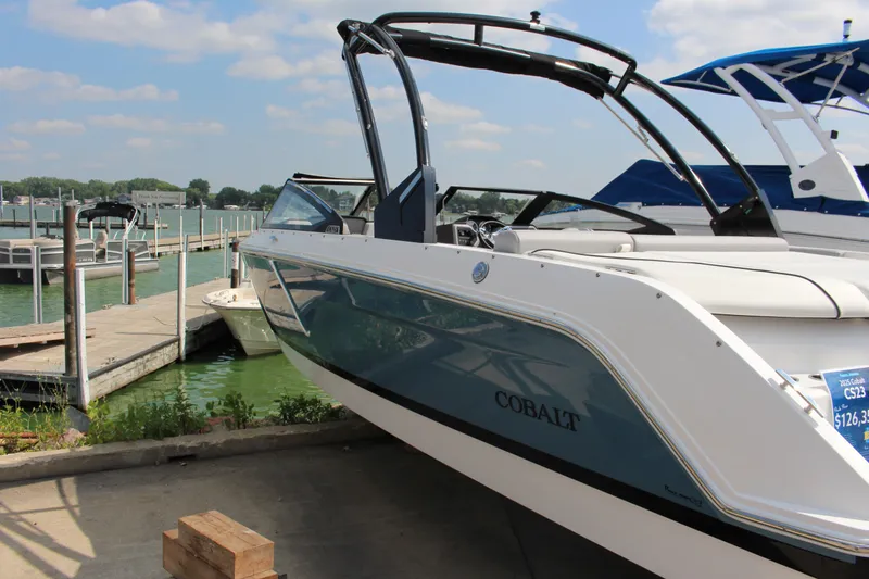 Slide: The Image of 2025 Cobalt CS23 boat docked by a serene lake under a blue sky. - 37