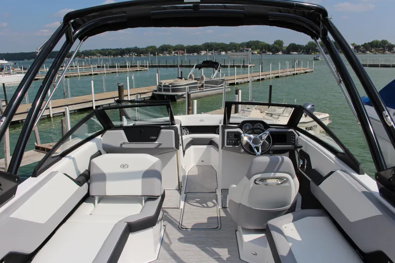 Slide: The Image of 2025 Cobalt CS23 boat interior with sleek design, docked at a scenic marina. - 4