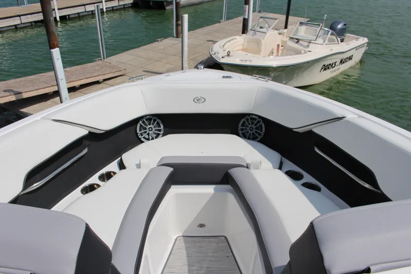 Slide: The Image of 2025 Cobalt CS23 boat interior with sleek seating and modern design at a marina. - 5
