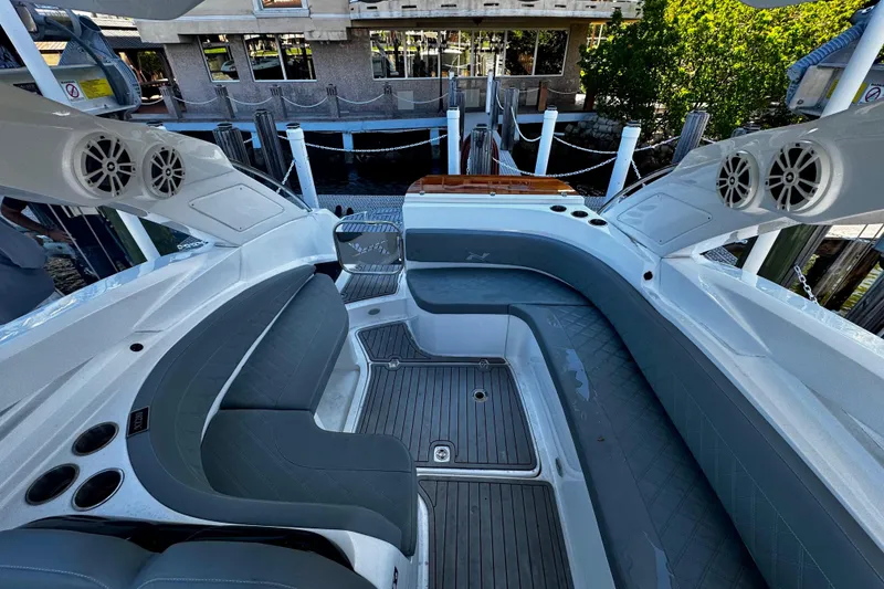 Slide: The Image of 2024 NX Boats NX 280 interior with sleek seating and modern design at a dock. - 13