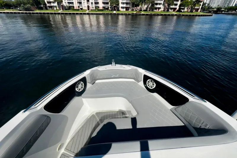 Slide: The Image of 2024 NX Boats NX 280 bow view with luxurious seating on calm water. - 22