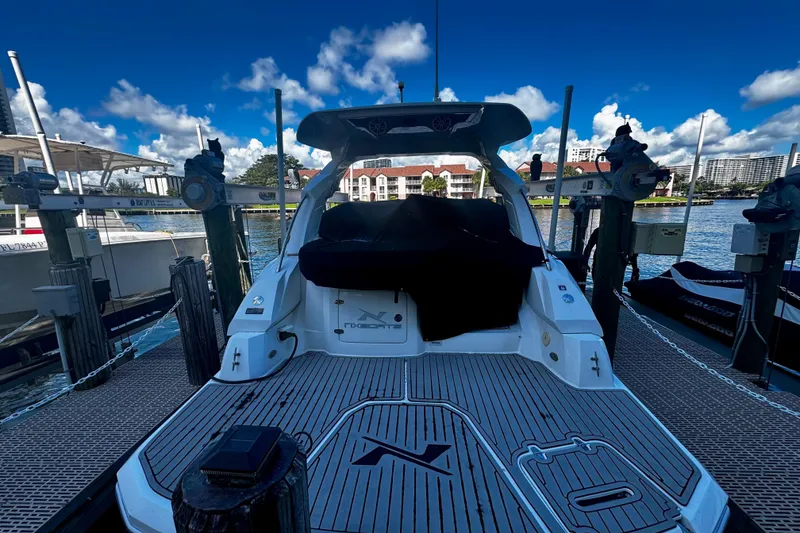 Slide: The Image of 2024 NX Boats NX 280 docked, showcasing sleek design and spacious deck. - 5