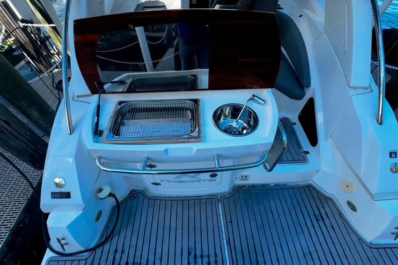 Slide: The Image of 2024 NX Boats NX 280 deck with sink and grill, featuring sleek design and modern amenities. - 8