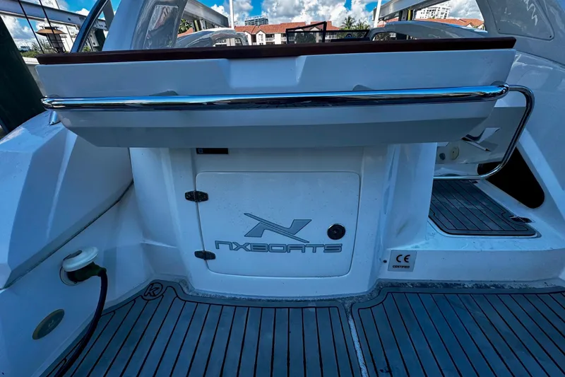 Slide: The Image of 2024 NX Boats NX 280, rear view with logo and deck details. - 9
