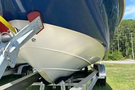 Slide: The Image of 2008 Everglades 290 CC boat on trailer, blue hull, parked on grass. - 10