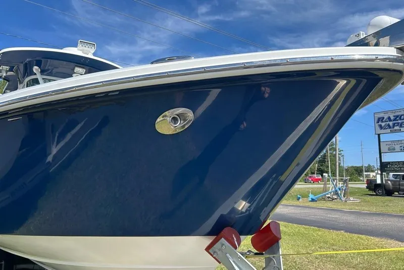 Slide: The Image of 2008 Everglades 290 CC boat with blue hull, parked outdoors under clear sky. - 3