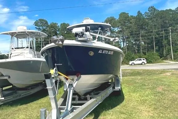 Slide: The Image of 2008 Everglades 290 CC boat on trailer, parked on grass, with trees and road in background. - 4