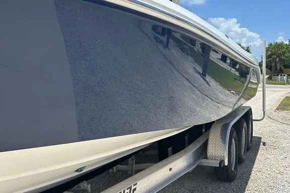 Slide: The Image of 2008 Everglades 290 CC boat on trailer, reflecting clear blue sky and greenery. - 6