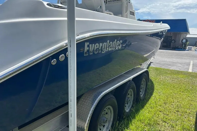 Slide: The Image of 2008 Everglades 290 CC boat on trailer, parked on grass under sunny sky. - 8