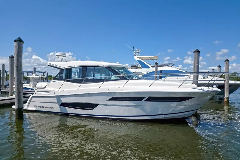 The Image of 2026 Regal 38 Grande Coupe yacht docked at marina under clear blue sky. - 0