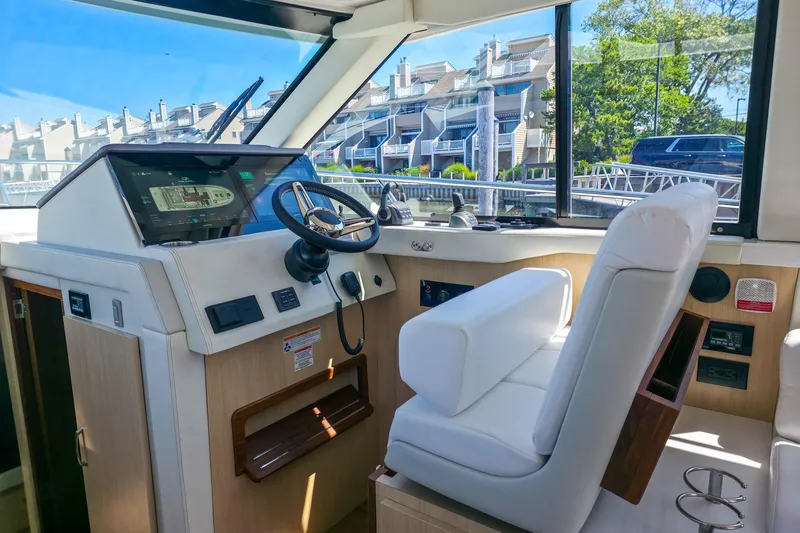 Slide: The Image of Interior helm of 2026 Regal 38 Grande Coupe yacht with modern controls and plush seating. - 26