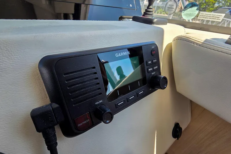 Slide: The Image of Garmin marine radio on 2026 Regal 38 Grande Coupe dashboard, featuring control knobs and display. - 39