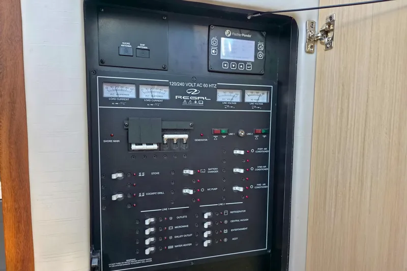 Slide: The Image of Electrical control panel of 2026 Regal 38 Grande Coupe boat, featuring various switches and meters. - 43