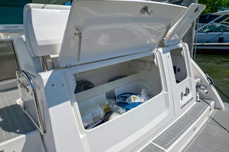 Slide: The Image of 2026 Regal 38 Grande Coupe boat storage compartment open, revealing interior contents. - 6