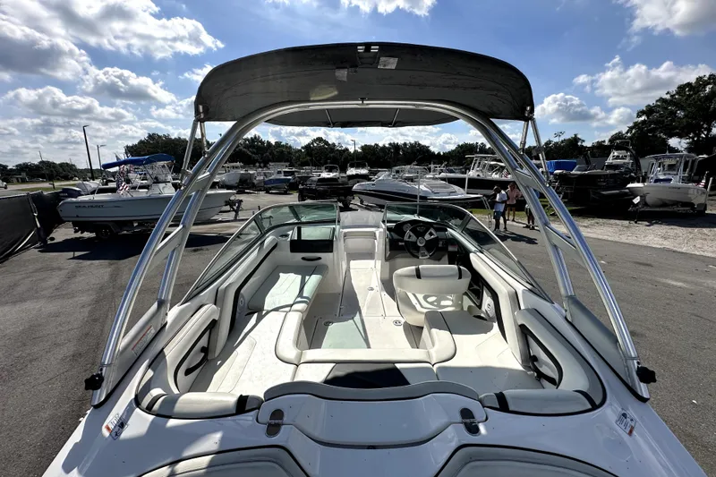 Slide: The Image of 2016 Yamaha Boats AR190 with sleek interior and canopy, parked in a marina. - 10