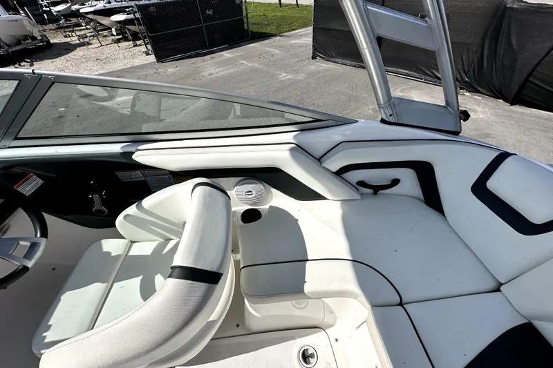 Slide: The Image of 2016 Yamaha Boats AR190 interior with white seating and steering wheel, docked outdoors. - 21
