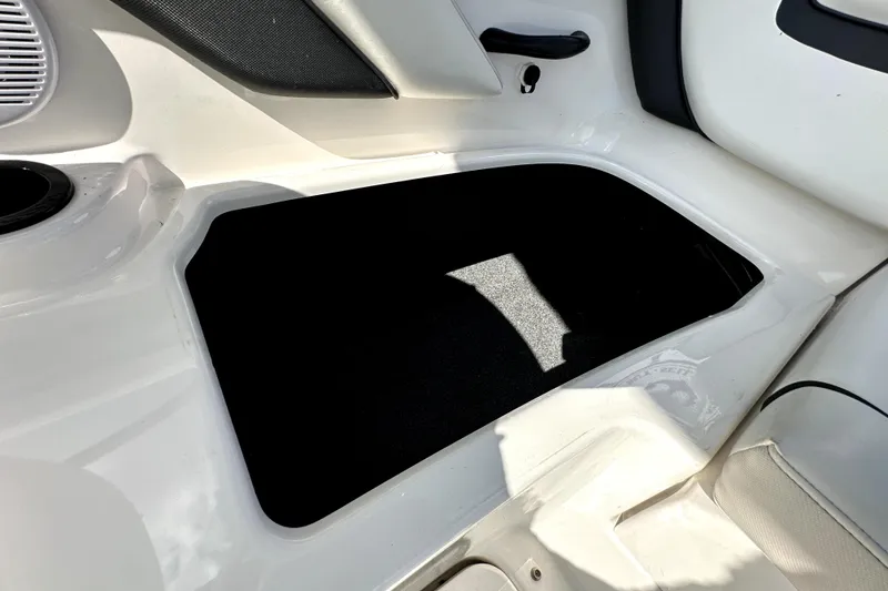 Slide: The Image of 2016 Yamaha AR190 boat storage compartment, white interior with black lining. - 23