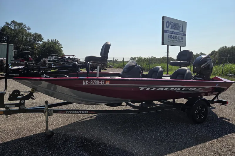 The Image of 2022 Tracker Pro Team 175 TXW boat on trailer, parked outdoors near marine dealership. - 0