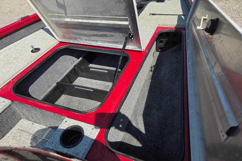 Slide: The Image of 2022 Tracker Pro Team 175 TXW boat storage compartments, open hatches, red and gray interior. - 9