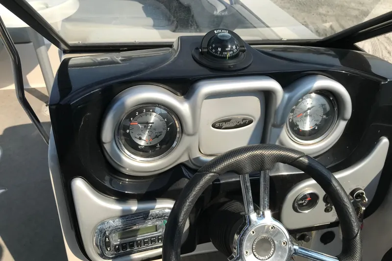 Slide: The Image of Dashboard of 2012 Starcraft Crossover 220 SCX IO boat with gauges and steering wheel. - 10