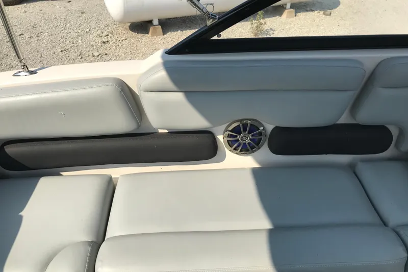 Slide: The Image of 2012 Starcraft Crossover 220 SCX IO boat interior with gray seating and speaker. - 22