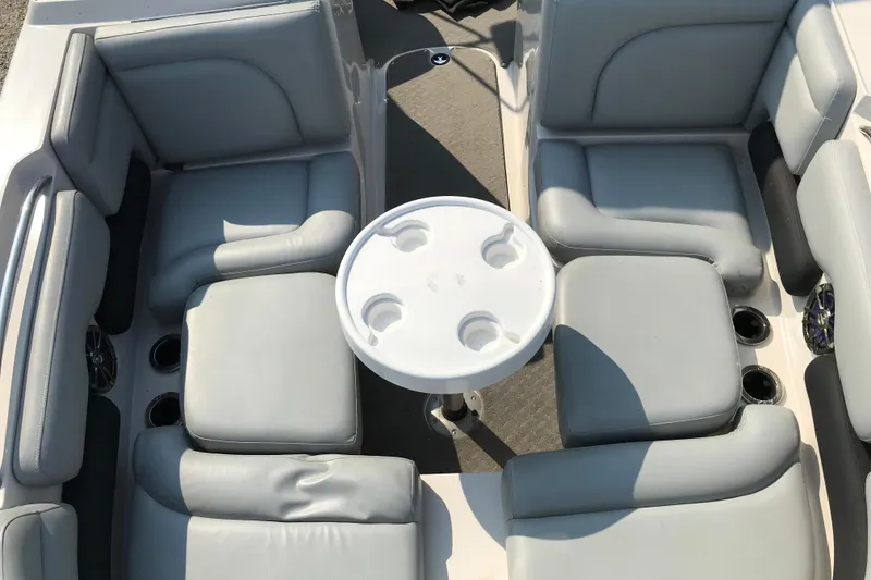 Slide: The Image of 2012 Starcraft Crossover 220 SCX IO boat interior with gray seating and round table. - 25