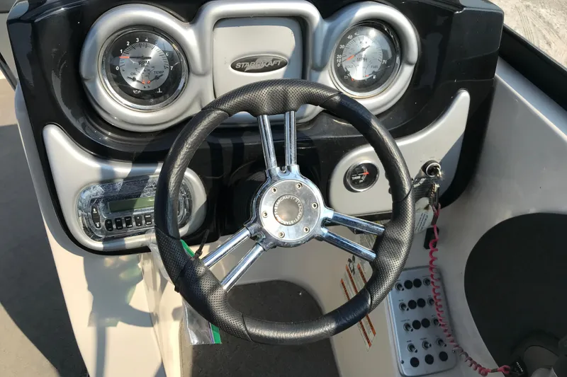 Slide: The Image of Steering console of 2012 Starcraft Crossover 220 SCX IO boat with gauges and controls. - 26