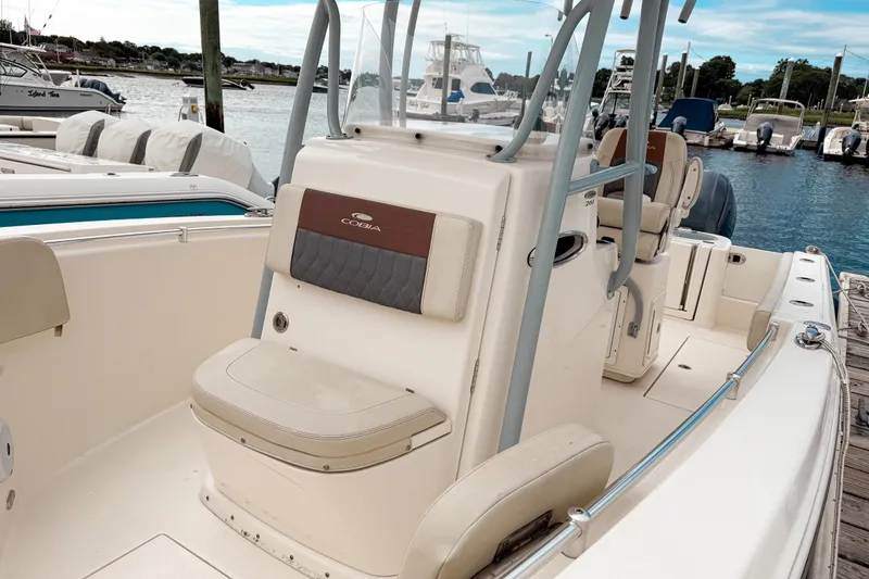 Slide: The Image of 2018 Cobia 261 Center Console boat docked at marina, featuring seating and console. - 10
