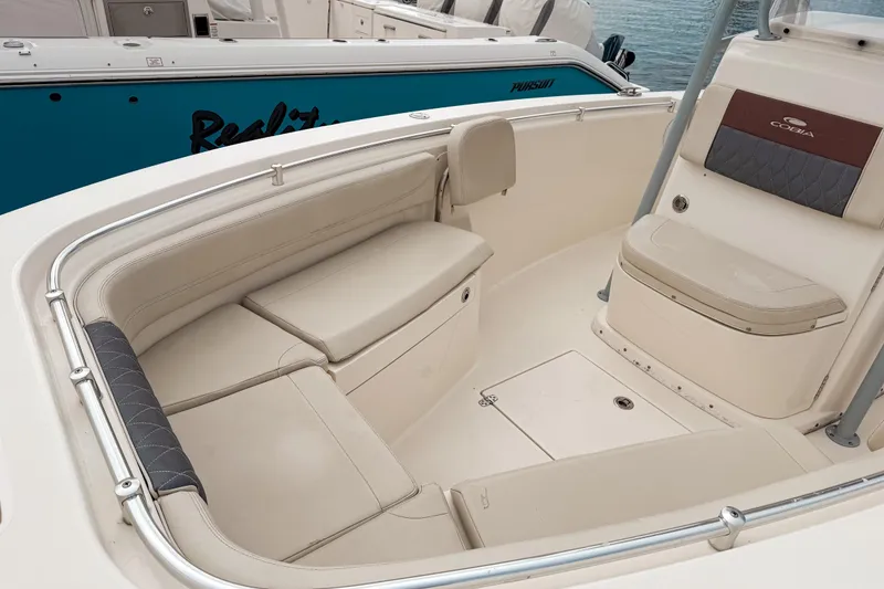 Slide: The Image of 2018 Cobia 261 Center Console boat interior with beige seating and storage compartments. - 12