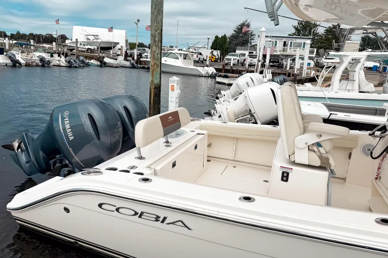 Slide: The Image of 2018 Cobia 261 Center Console boat docked with Yamaha engines in a marina. - 4