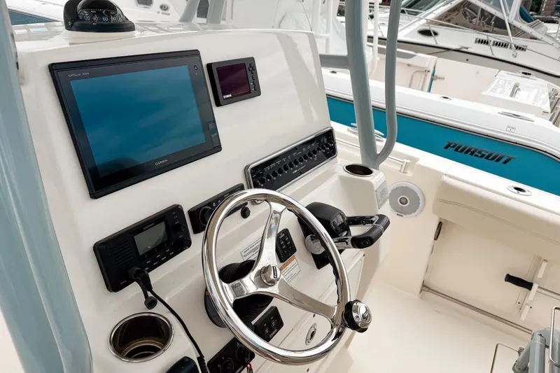 Slide: The Image of 2018 Cobia 261 Center Console boat dashboard with steering wheel and navigation equipment. - 9