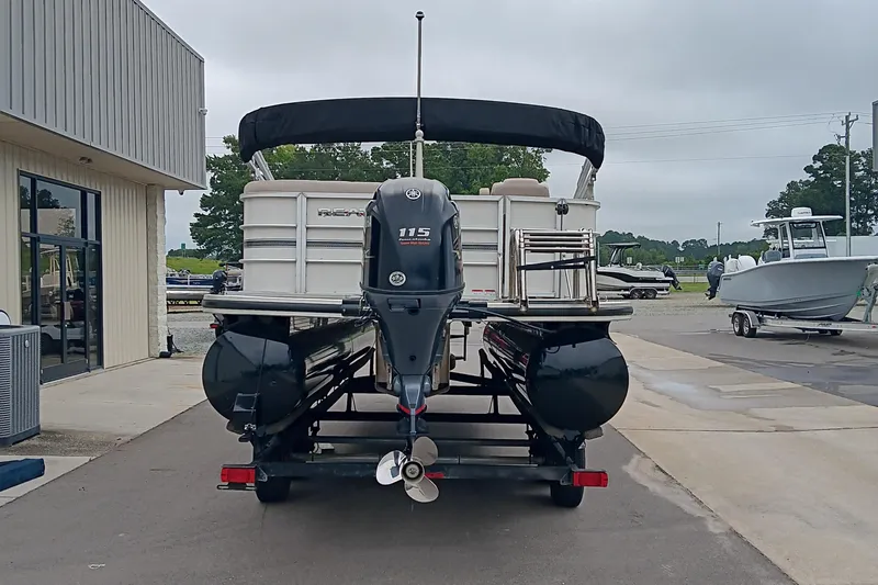 Slide: The Image of 2017 Ranger Reata 220C pontoon boat with 115 horsepower engine, parked at a marina. - 6