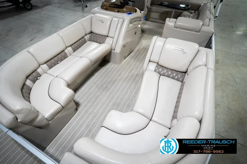 Slide: The Image of 2016 Bennington 2375 RSB pontoon boat in indoor showroom, blue and white design. - 11