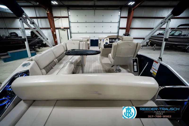 Slide: The Image of 2016 Bennington 2375 RSB pontoon boat interior with seating and table in showroom. - 18