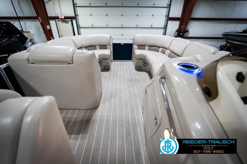Slide: The Image of 2016 Bennington 2375 RSB pontoon boat interior with beige seating in a showroom. - 19