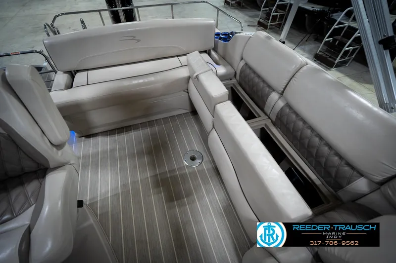 Slide: The Image of 2016 Bennington 2375 RSB boat interior with beige seating and striped flooring. - 26
