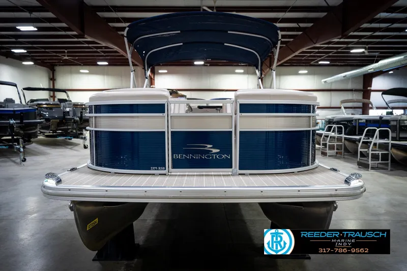 Slide: The Image of 2016 Bennington 2375 RSB pontoon boat with blue canopy in indoor showroom. - 4