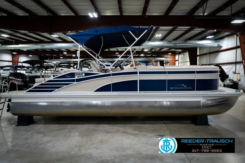 Slide: The Image of 2016 Bennington 2375 RSB pontoon boat with blue canopy in indoor showroom. - 6