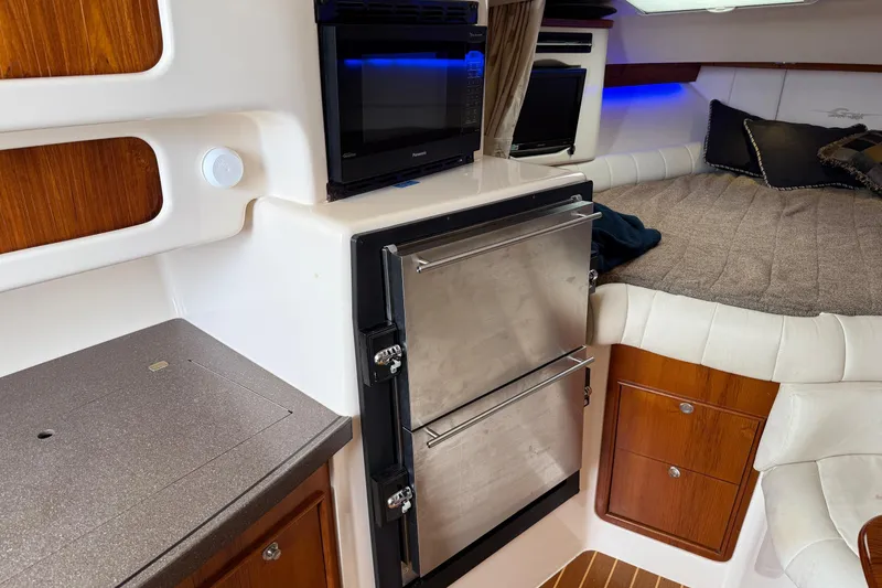 Slide: The Image of 2008 Grady-White Express 360 cabin interior with bed, microwave, and fridge. - 12